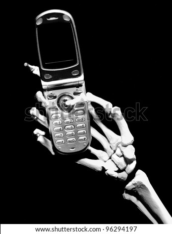 Skeleton hand holding a generic cell phone with a blank screen, isolated on black