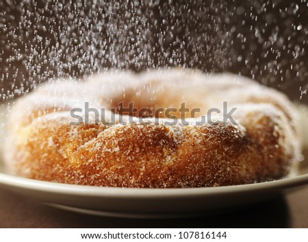 Sprinkling a crown cake with sugar