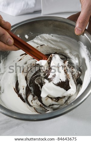 Mixing together the beaten egg whites and the melted chocolate