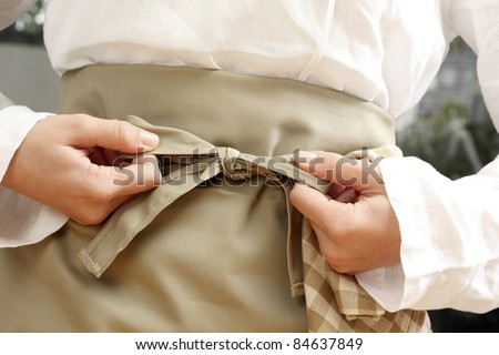 Tying  an apron around the waist