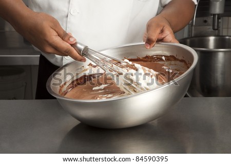 Cook mixing together the whipped egg whites to the melted chocolate
