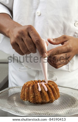 Cook decorating a cake with icing sugar with a piping bag
