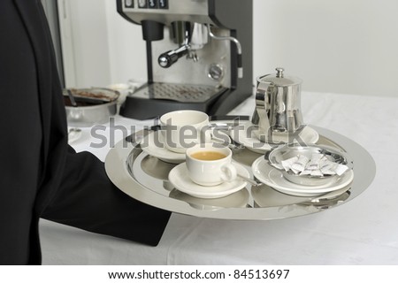 Waiter serving hot drinks on a tray