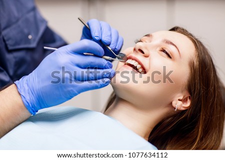Dentist check-up teeth to young woman patient in clinic.