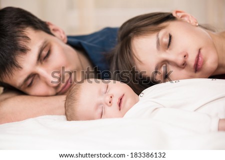 Sleeping baby with mom and dad, closeup