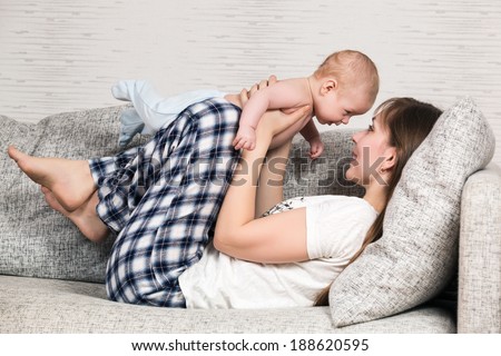Happy mother playing with her cute loving baby at home