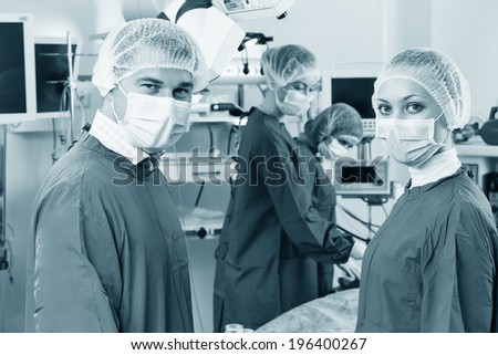 Portrait of surgeons in surgery with doctors working on background