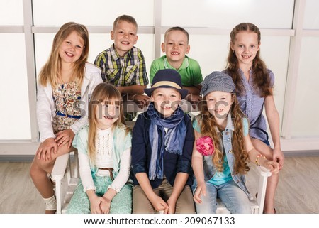 Portrait of group of kids sitting on the couch at home, hugging, smiling and laughing