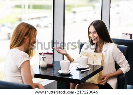The young women with shopping bag in the cafe The young women with shopping bag in the cafe