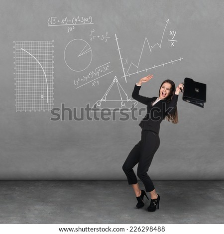 Scared young businesswoman with briefcase and gesturing fear in dark room with graphs