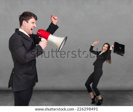 dissatisfied man screaming at small scared woman over dark background