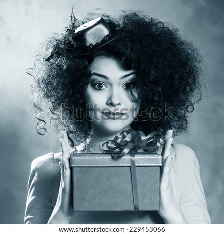 Portrait of a beautiful happy female with red box in hands