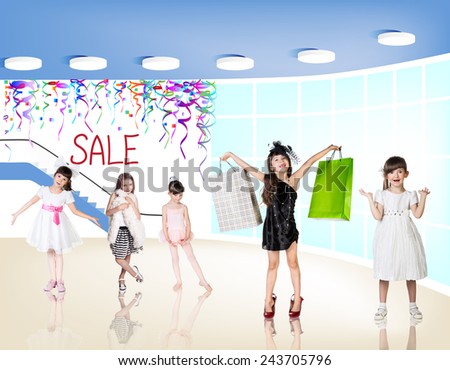 Little fashion girls with packages in a large shopping center. Pretty smiling little girls with shopping bags posing in the shop