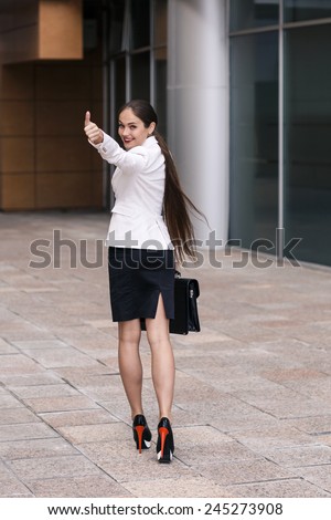 Beautiful businesswoman walk away and show thumb up