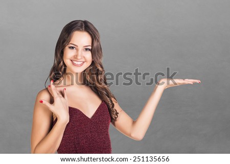 happy young woman showing a product - empty copy space on the open hand palm, over white background