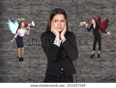 Young troubled businesswoman making choice between good and bad on grey brick background
