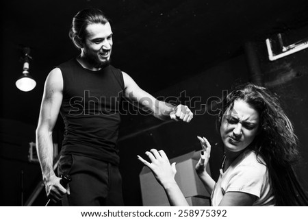 Man beating up his wife on black-and-white background