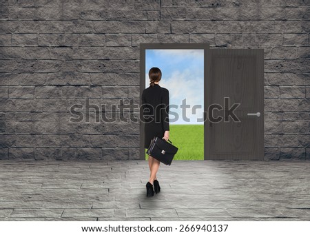 Composite image of Businesswoman walking away in room with door