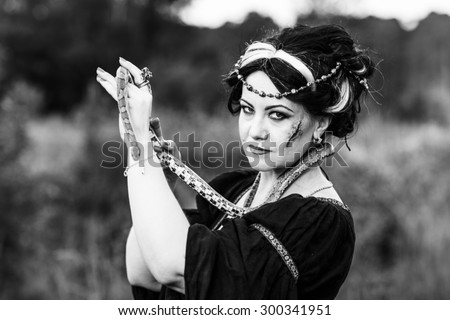 Ugly woman with snake. Witch conjure outdoors