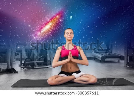 Woman practicing meditation yoga against the background of the galaxy