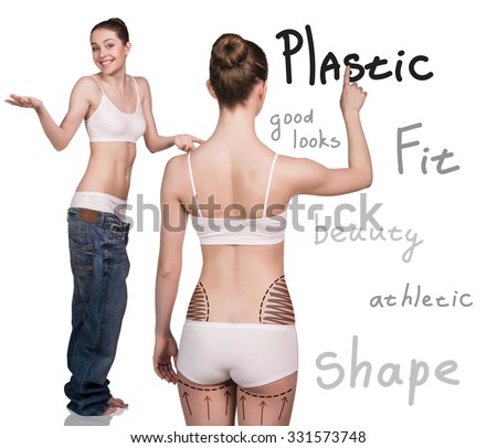 Young woman stands back and makes a notes on the wall. Isolated plastic boby.