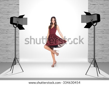Model in photo studio room with white cloth and spotlights