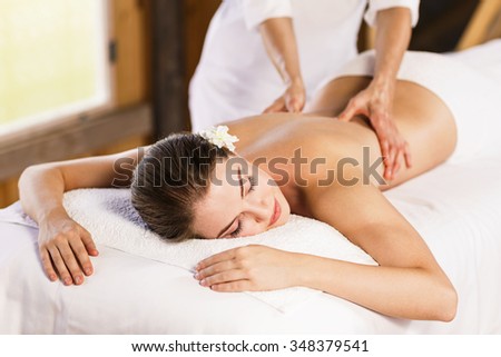 Young beautiful girl lying on massage table and enjoying massage.