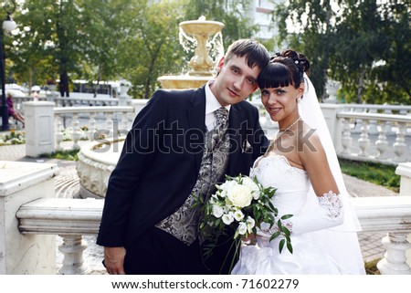 Bride and groom posing with the fountain on the background