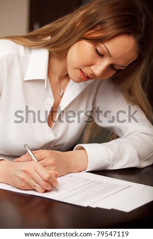 Attractive young woman signing contract