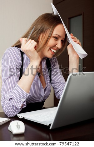 A stressed business woman laughing in front of laptop