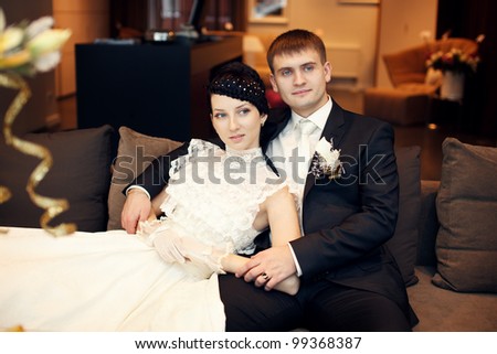 Newlyweds sitting on the sofa in the hall