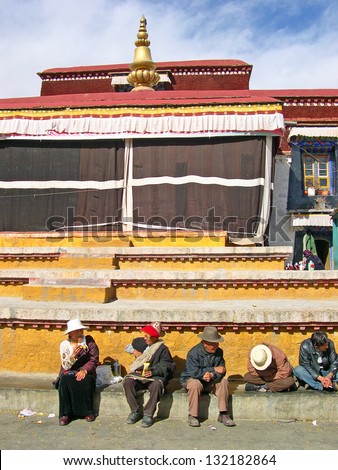 LHASA, TIBET-NOVEMBER 12: Tibetans sitting in front of the Jokhang temple. This historic temple is the holiest site in Tibetan Buddhism. November 12, 2004 in Lhasa, Tibet