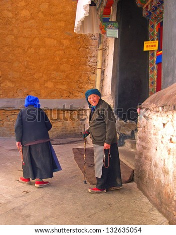 LHASA, TIBET-NOVEMBER 12: two old ladies exit the Drepung temple. The temple houses about 700 monks and attracts over 1 million visitors each year.  November 12, 2004 in Lhasa, Tibet
