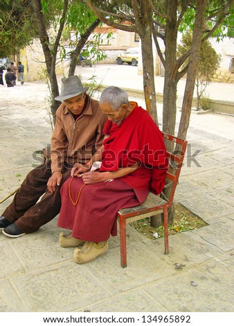LHASA, TIBET-NOVEMBER 13: Pilgrim and monk debating at the Sera temple. This historic temple is the holiest sites in Tibetan Buddhism. November 13, 2004 in Lhasa, Tibet