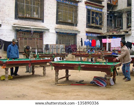 LHASA, TIBET-NOVEMBER 13: young Tibetans playing billiard in Barkhor Street area. The ancient street is a symbol of Lhasa and a must see place for visitors. November 13, 2004 in Lhasa, Tibet