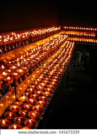 LHASA, TIBET-NOVEMBER 14: Dark room with many prayer candles in Ramoche Temple.  The temple is considered the most important in Lhasa after the Jokhang Temple. November 14, 2004 Lhasa, Tibet