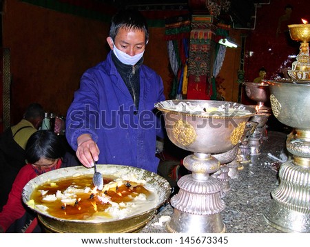 LHASA, TIBET-NOVEMBER 14: man attending prayer candles at Tsepak  Lakhang  temple. The temple is considered one of the most important temples in Lhasa. November 14, 2004 Lhasa, Tibet