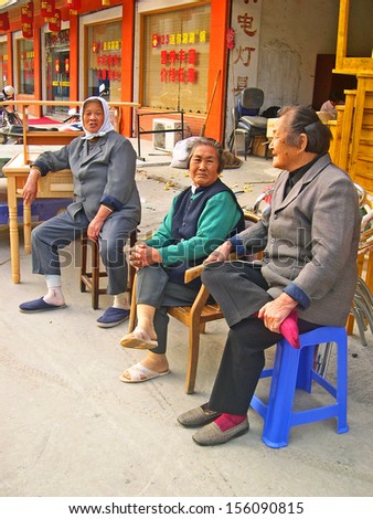 LUZHI, SHANGHAI, CHINA Ã¢Â?Â? OCTOBER 30 ladies sitting and chatting in the main street.  The village is a Shanghai tourist attraction with 100000 visitors per year. October 30, 2004 Luzhi, China.