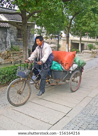 LUZHI, SHANGHAI, CHINA -Â?Â? OCTOBER 30: guy delivering goods. The ancient village is a Shanghai tourist attraction with 100000 visitors per year. October 30, 2004 Luzhi, China.