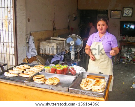 LUZHI, SHANGHAI, CHINA -Â?Â? OCTOBER 30: lady selling focaccia and drink. The ancient village is a Shanghai tourist attraction with 100000 visitors per year. October 30, 2004 Luzhi, China.