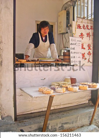 LUZHI, SHANGHAI, CHINA -Â?Â? OCTOBER 30: lady attending a characteristic cake shop. The ancient village is a Shanghai tourist attraction with 100000 visitors per year. October 30, 2004 Luzhi, China.