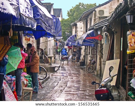 JINXI, SHANGHAI, CHINA  FEBRUARY 6: typical village lane under the rain. The ancient village is a Shanghai tourist attraction with 100000 visitors per year. February 6, 2005, Jinxi, China