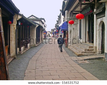JINXI, SHANGHAI, CHINA  FEBRUARY 6: local walking in a village typical street. The ancient village is a Shanghai tourist attraction with 100000 visitors per year. February 6, 2005, Jinxi, China