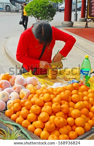 NANXUN, SHANGHAI, CHINA -Â?Â? APRIL 11:young lady selling pineapples and oranges, The Nanxun water town is Shanghai tourist attraction with 100000 visitors year. April 11, 2007,Nanxun, China
