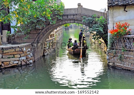 Zhouzhuang, a Shanghai tourist attraction. Boat with tourists  in a village canal.