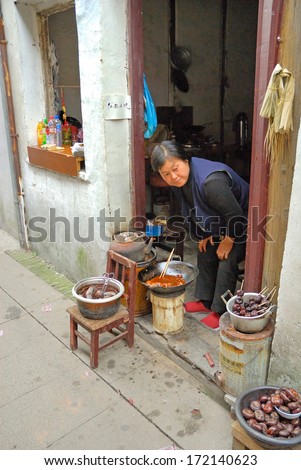 ZHOUZHUANG, SHANGHAI-MAY 12: lady running an old village street shop. Zhouzhuang water village is Shanghai tourist attraction with 1000000 visitors year May 12, 2007 Zhouzhuang, China