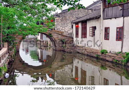 Zhouzhuang, a Shanghai tourist attraction. Old houses and bridge reflection in a village canal.