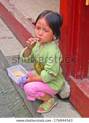 QIBAO, SHANGHAI-SEPTEMBER 4: unidentified young lady enjoying sweets. Qibao water village is Shanghai tourist attraction with 1000000 visitors year. September 4, 2004 Qibao, Shanghai.