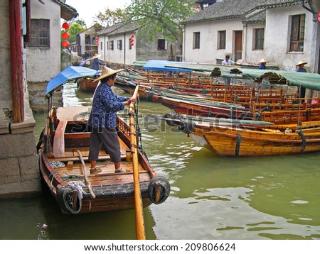 ZHOUZHUANG, SHANGHAI-SEPTEMBER 25, 2005: lady running a boats for tourists. Zhouzhuang water village is Shanghai tourist attraction with 1000000 visitors year