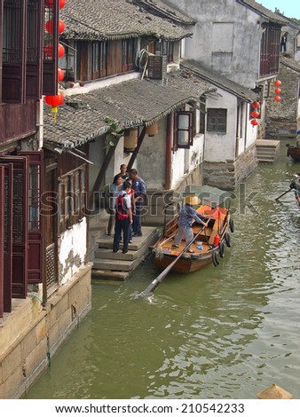 ZHOUZHUANG, SHANGHAI-SEPTEMBER 25, 2005: lady preparing to board tourists in the main canal.  Zhouzhuang water village is Shanghai tourist attraction with 1000000 visitors year